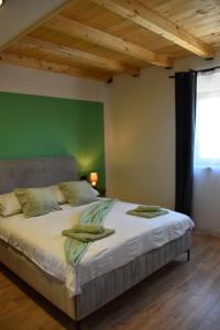 a bedroom with a large bed with a green wall at Apartments Rismondi 37E in Fažana