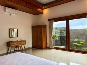 a bedroom with a bed and a desk and a window at Obah Villa Ubud 1 Br Brand new private villa in Ubud