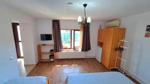 a living room with a large window and wooden floors at Briza Marii in Sfântu Gheorghe