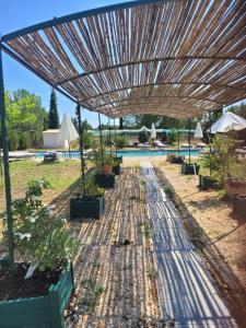 a wooden umbrella over some plants in a yard at Villa Blanche - Teritoria in Arles