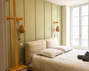 a bedroom with a bed with two pillows and a window at Appartement rénové hyper centre in Marmande