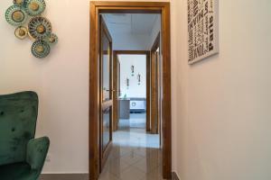 a hallway with a green chair and a mirror at AlbaChiara in Alghero +20 photos