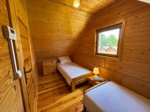 a room with two beds in a wooden cabin at Domki Pajka in Międzyzdroje