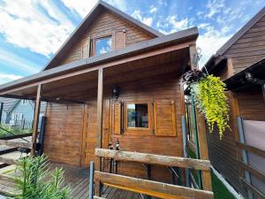 a wooden cabin with a porch and a fence at Domki Pajka in Międzyzdroje