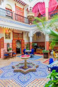 a lobby with a fountain in the middle of a building at Riad bleu du Sud in Marrakesh