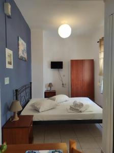 a bedroom with a large white bed with a blue wall at Chalkidonos in Heraklio Town