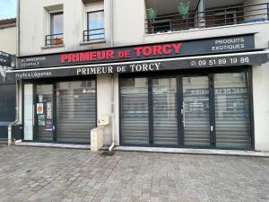 a store front with four garage doors on a street at Le cocon du centre ville in Torcy