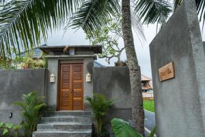 a door to a house with a palm tree at Obah Villa Ubud 1 Br Brand new private villa in Ubud