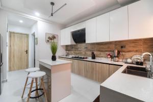 a kitchen with white and wooden cabinets and a counter at Luxury Lagos Apartment with 3 Bedrooms in Lagos
