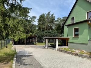 a green building with a pavilion in front of it at Ferienhaus Family and Friends am Knappensee in Knappenrode