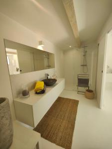 a bathroom with a sink and a mirror at La Maison l'Oliveraie in Lunel