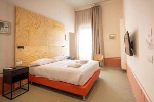 una habitación de hotel con una cama y un televisor en Don Vittorio a Chiaia, en Nápoles