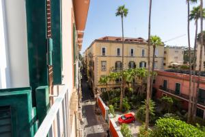 un coche rojo estacionado en una calle con edificios en Don Vittorio a Chiaia, en Nápoles