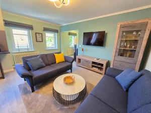 ein Wohnzimmer mit zwei Sofas und einem Fernseher in der Unterkunft Strandvillen Binz - Ferienwohnung mit Panoramablick, 2 Schlafzimmern und Balkon SV-715 in Binz