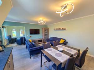 ein Wohnzimmer mit einem Tisch und einem blauen Sofa in der Unterkunft Strandvillen Binz - Ferienwohnung mit Panoramablick, 2 Schlafzimmern und Balkon SV-715 in Binz