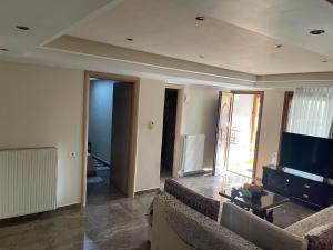 a living room with a couch and a tv at IslandTime Studio2 in Prinos