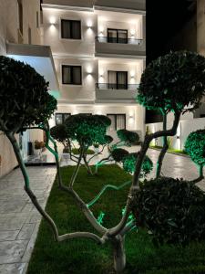 ein Gebäude mit Bäumen vor einem Gebäude in der Unterkunft Hotel Vila Dedej in Durrës