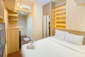 RawalembangにあるGood and Simply Studio Tokyo Riverside PIK 2 Apartment By Travelioの部屋に白いベッドがある寝室