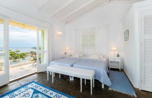 a white bedroom with a bed and a large window at Bay View Hotel in (( Klonátika ))