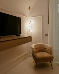 a living room with a chair and a flat screen tv at Luxury apartment-Quartieri Spagn by Alux38 in Naples