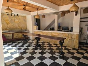 un bar con tavolo in legno su un pavimento a scacchi di Dhow Palace Hotel a Zanzibar City