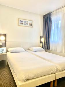 Postel nebo postele na pokoji v ubytování Brit Hotel Lyon Nord Dardilly