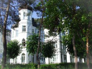 ein weißes Haus mit Bäumen davor in der Unterkunft Strandvillen Binz - Ferienwohnung mit Panoramablick, 2 Schlafzimmern und Balkon SV-715 in Binz