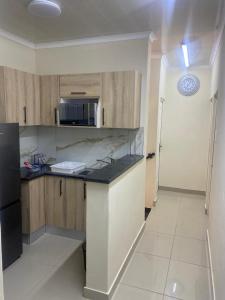 a kitchen with wooden cabinets and a black refrigerator at Sabbath Lodge VIP in Cape Town