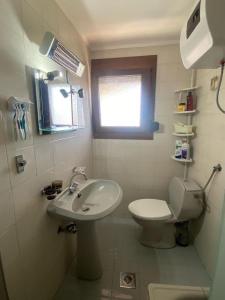 a bathroom with a sink and a toilet and a window at IslandTime Studio2 in Prinos +9 photos