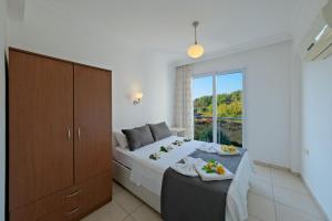 a bedroom with a bed and a large window at Legend Apartments II Fethiye in Fethiye