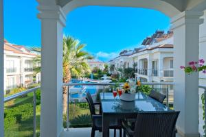 a table on a balcony with a view of a pool at Legend Apartments II Fethiye in Fethiye
