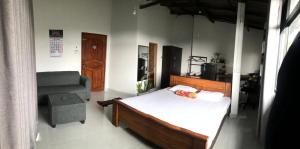 a bedroom with a bed and a chair at S V homestay in Kandy