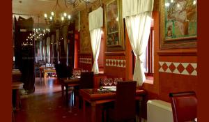 a dining room with tables and chairs and a chandelier at Hotel Boutique Palacio de la Serna in Ballesteros de Calatrava