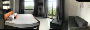 a bedroom with a bed and a chair and a window at S V homestay in Kandy