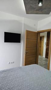 a bedroom with a bed and a wooden door at Apartman Sara in Bihać