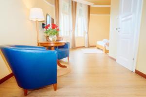 a living room with a blue chair and a table at BRISTOL Hotel Opatija in Opatija