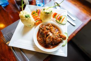 a plate of food with a bowl of stew and vegetables at Hadassah Hotel in Nairobi +28 photos
