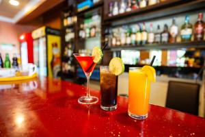 three cocktails sitting on top of a bar at Hadassah Hotel in Nairobi