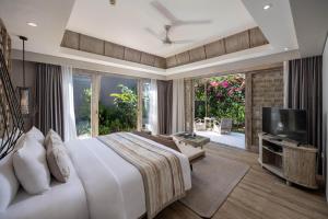 a bedroom with a large bed and a tv at Cross Bali Breakers in Jimbaran