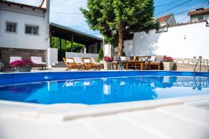 a swimming pool in front of a house at Vila Mila in Arandjelovac
