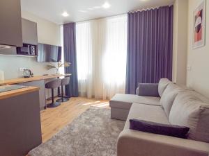 a living room with a couch and a kitchen at Smart House Apartments in Lviv