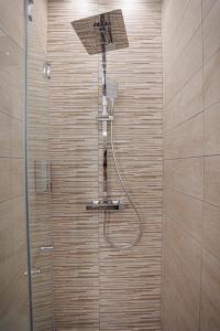 a shower with a shower head in a bathroom at Monia Rooms&Hospitality in Piazza Armerina
