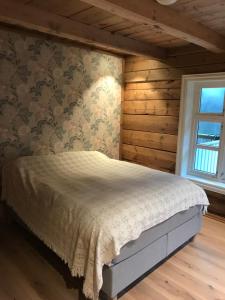 a bedroom with a bed in a room with wooden walls at Jostedal Lodge in Jostedal
