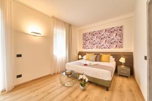 a bedroom with a bed and a painting on the wall at Boutique Hotel Villa Cuserina wellness in Cannobio +49 photos