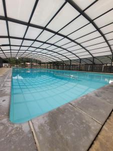 a large swimming pool with a large ceiling at Chalet familial entre lac et fôret in Azur +26 photos