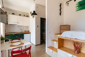 a kitchen with a table and a bed in a room at TheKeyStudio, Viva ITALIA con giardino, in 2 minuto dal mare in Bordighera