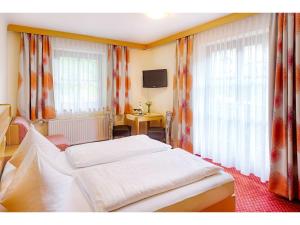 a hotel room with two beds and a television at Landhotel Almrösl im Großarltal in Hüttschlag