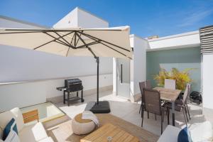 a patio with a table and an umbrella at Fahana Las Canteras in Las Palmas de Gran Canaria