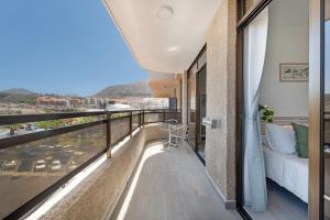 a balcony with a bed and a view of a city at Apto Sasha Los Cristianos in Arona