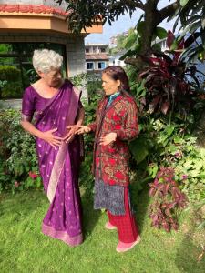 two women standing next to each other in a yard at Hotel Diplomat in Pokhara